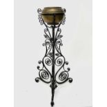 An Arts and Crafts wrought iron jardiniere stand, with spiral and scroll decoration, fitted a