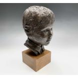 A bronzed head of boy, signed Judy Boot, on wooden plinth. Height 34cm overall.