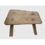 An elm small pig bench, 19th century, of rustic form, with a substantial solid top on four splay