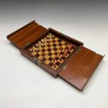 A mahogany folding travel chess set, circa 1900, with red stained and natural bone pieces, width