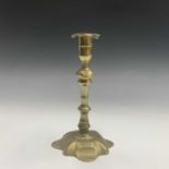 An 18th century brass candlestick, with knopped stem on shaped square base, height 20cm.