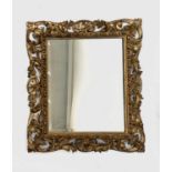 A Florentine gilt carved wall mirror, circa 1900, with rectangular bevelled plate, 70 x 60cm.