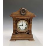A late Victorian oak cased mantel clock, with applied rose motif. Height 36cm.