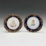A pair of Sevres porcelain plates, each with a signed portrait within royal blue and gilt borders,