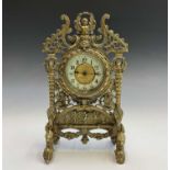 A Continental brass cased timepiece, the ornate strut surround cast and pierced with winged cherubs,