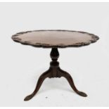 A George III mahogany tripod table, the snap top with foliate carved rim on an acanthus leaf