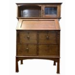 An Arts and Crafts oak bureau cabinet, the upper part with a fitted lead glazed door, above a fall