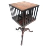 A mahogany revolving book stand, with leather inset top and slatted end supports, raised on a George