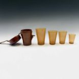A set of 19th century graduated horn cups, the largest 11cm high, contained in a leather holder,