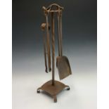 An Arts and Crafts period steel fireside companion set, the stand with dragon surmount and fitted