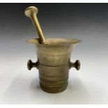 A 19th century brass mortar and pestle. Height of mortar 12cm, length of pestle 21.5cm.