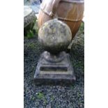A cast stone gate post finial of spherical form on stepped base. Height 44cm.