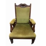 A Late Victorian walnut gentlemans armchair, with green upholstery.