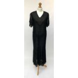 An elegant black lace 1920s short sleeved full length dress with silk chiffon inserts.