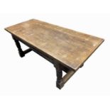 An oak refectory table, with a carved frieze on turned legs, joined by a 'H' stretcher, height 76cm,