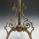 A Victorian brass lamp stand with scrolled supports and base, and lion's paw feet. Height 114cm.