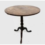 A George III mahogany tripod table, the circular snap top on a turned baluster stem and downswept