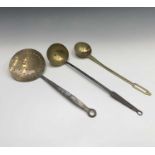 An 18th century brass and steel cream skimmer, length 49cm, together with two ladles (3).