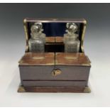 An Edwardian oak and brass mounted tantalus, fitted two (of three) cut glass decanters and
