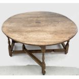 A large oak gateleg dining table, 18th century, the oval top above a frieze drawer opposed by a