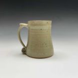 A Leach studio pottery mug, the handle with scroll terminal. Height 11.5cm.