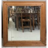 A mirror in antique pine frame. 106cm x 99cm overall.