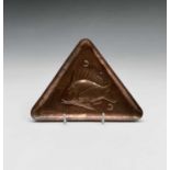 A Newlyn copper pin tray of triangular form, repousse decorated with a fish, stamped Newlyn.