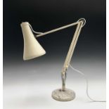 A mid century Herbert Terry & Sons cream painted metal Anglepoise desk lamp on circular base.