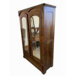 A German stained beech wardrobe, late 19th century, with a pair of mirrored doors above a single