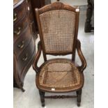 An Edwardian walnut armchair, with cane back and seat, on turned legs, height 86cm.