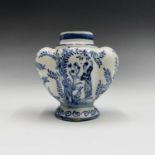 A 19th century Dutch Delft small vase, of lobed heart shape, painted with a figure in a garden,