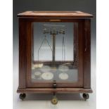 A glazed mahogany laboratory chemical balance, the scale signed W & J George Ltd, Birmingham and F F