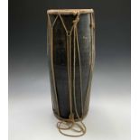 An ethnic barrel drum with black lacquered finish with animal hide ends, height 58cm.