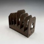 An arts and crafts oak letter or toast rack, with trefoil pierced decoration on a stepped base,