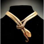 A 9ct gold snake necklace the head and tail set with rubies, the eyes demantoid garnets