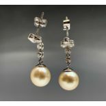 A pair of choice pearl earrings each is of 9.3mm diameter, they hang from a bright diamond trefoil