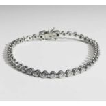 An 18ct white gold tennis bracelet, set with a line of numerous diamonds in articulated links.