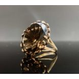 A gold ring set with a large faceted smoky topaz, 6.3g.