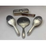 A pair of silver-mounted brushes, a matching mirror and an ornate silver-mounted brush and a