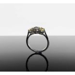 An unusual platinum ring with a diamond set between a pair of yellow sapphires.Approx size: K1/2