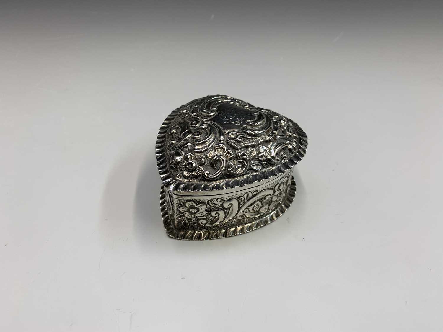 A heart-shaped silver late Victorian box by George Unite with ornate embossed decoration and