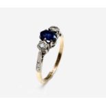 An 18ct gold ring set an oval sapphire and two diamonds.Approx size: N