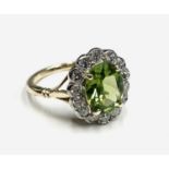 A peridot and diamond oval cluster ring.Approx size: N1/2-O leading edge