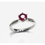 An 18ct white gold ruby ring with diamond shoulders.Approx size: L1/2 - M leading edge.