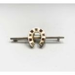 A Victorian 9ct matte gold bar brooch with a horseshoe set rubies and diamonds