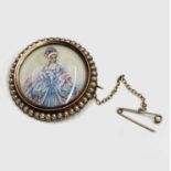 A 15ct gold brooch set a miniature painting of a crinoline lady within a border of pearls,