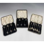 Two sets of six silver bean knop coffee spoons, cased and one other cased set of six silver coffee
