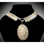 A Victorian Aesthetic Movement silver locket Birmingham 1863 it hangs from a fringed silver engraved