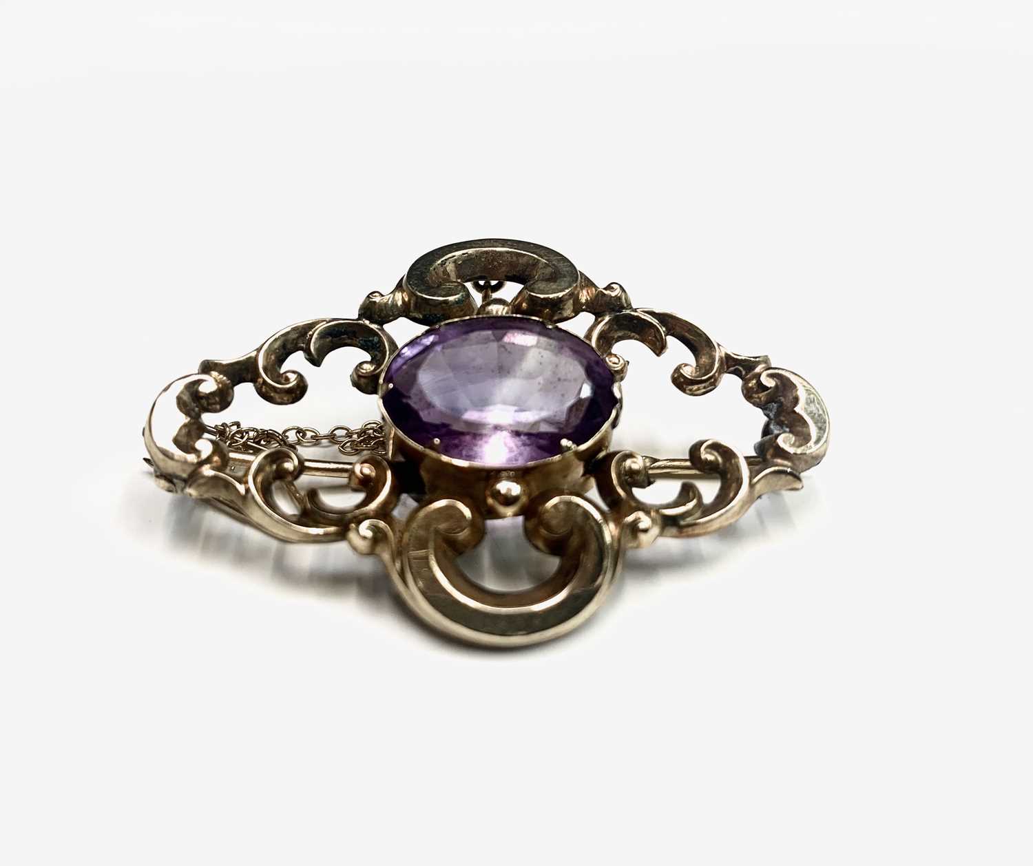 A Victorian scrolling gold brooch set an amethyst 48mm 8.6gm