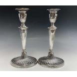 A pair of Adam style silver candlesticks by Charles Stuart Harris junior London 1891, each has